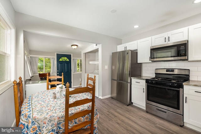 59 Transverse Ave, Middle River, MD 21220 - kitchen with appliances with stainless steel finishes, separate washer and dryer, tasteful backsplash, white cabinetry, and dark wood finished floors
