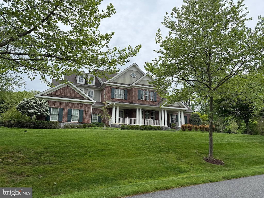 craftsman-style home featuring a front lawn, a porch, and brick siding