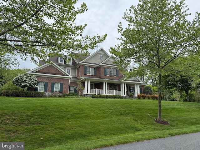 craftsman-style home featuring a front lawn, a porch, and brick siding