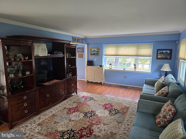 living area featuring crown molding, baseboards, and wood finished floors