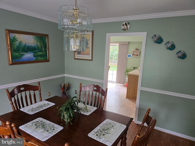 dining room with crown molding, wood finished floors, and baseboards