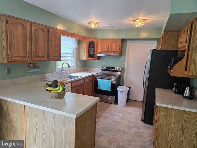 kitchen featuring under cabinet range hood, a sink, a peninsula, stainless steel range with electric cooktop, and light countertops