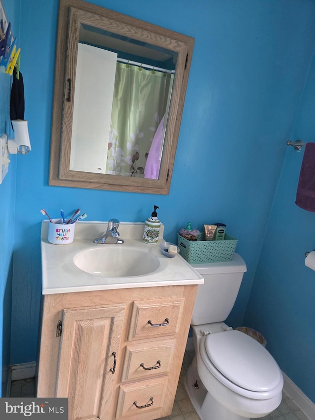 full bathroom featuring vanity, toilet, baseboards, and tile patterned flooring