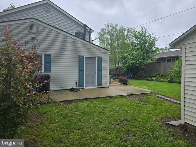 back of house with fence, a patio area, and a lawn