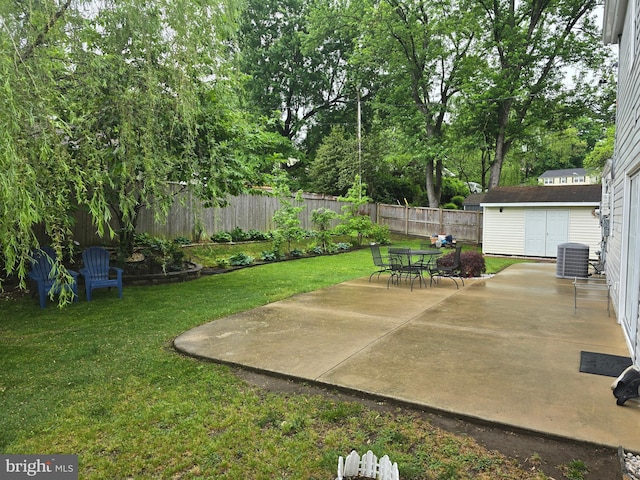 view of yard featuring an outdoor structure, a patio, a shed, central AC unit, and a fenced backyard
