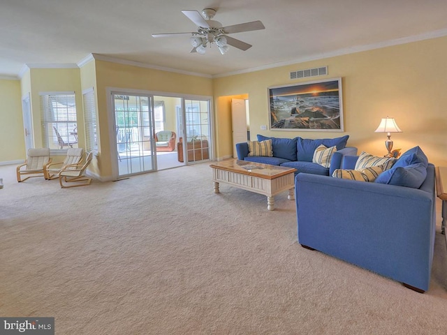 living room with ornamental molding, visible vents, carpet flooring, a ceiling fan, and baseboards