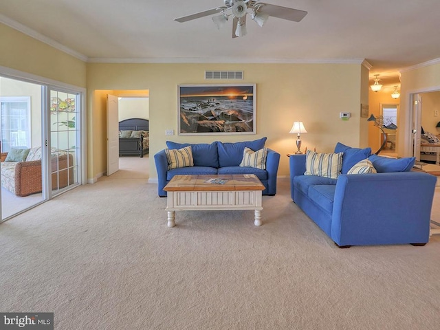 carpeted living area with crown molding, baseboards, a ceiling fan, and visible vents