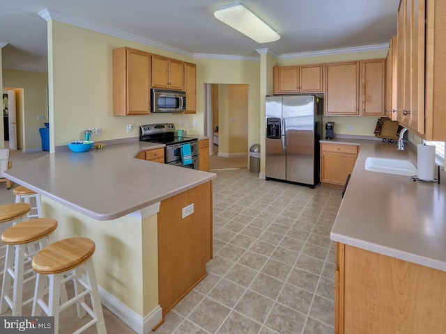 kitchen with a peninsula, a breakfast bar, crown molding, light countertops, and appliances with stainless steel finishes