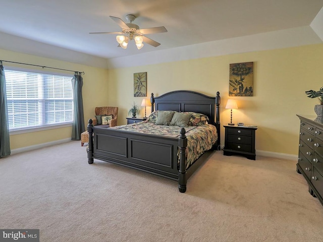 bedroom featuring light carpet, baseboards, and a ceiling fan