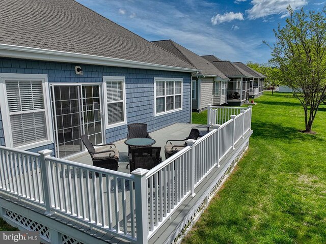 wooden terrace featuring a yard