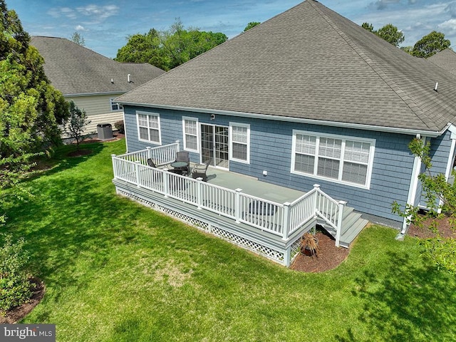 rear view of house featuring a shingled roof, central AC unit, a wooden deck, and a lawn