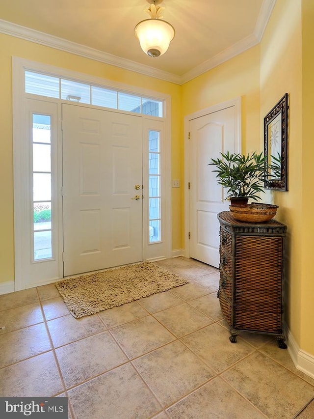 foyer entrance with baseboards, ornamental molding, and light tile patterned flooring