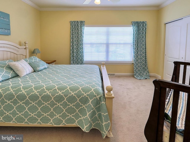 carpeted bedroom featuring baseboards, crown molding, and a ceiling fan
