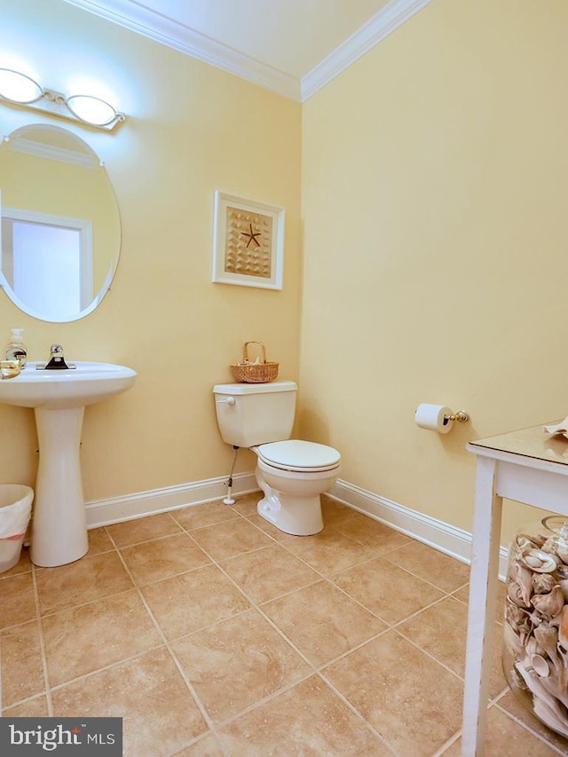 half bath with baseboards, toilet, ornamental molding, and tile patterned flooring