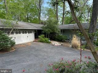 view of front facade with asphalt driveway and an attached garage
