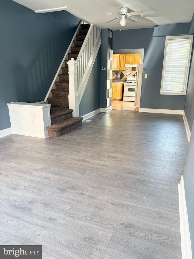 2302 E Albert St, Philadelphia, PA 19125 - unfurnished living room featuring light wood-type flooring, stairs, baseboards, and a ceiling fan