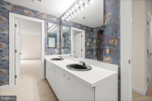 full bath with a sink, wallpapered walls, and visible vents