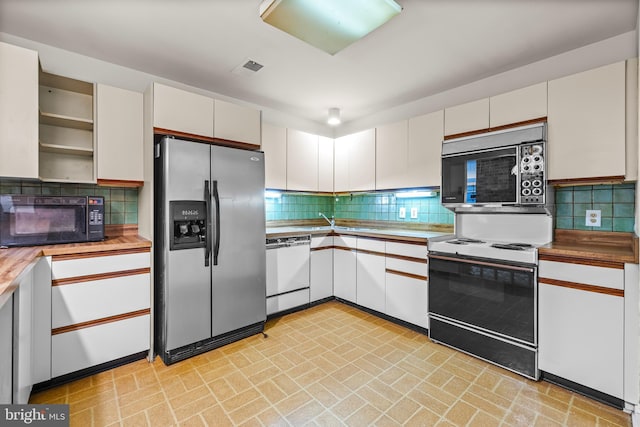 kitchen featuring dishwasher, black microwave, open shelves, electric stove, and stainless steel refrigerator with ice dispenser