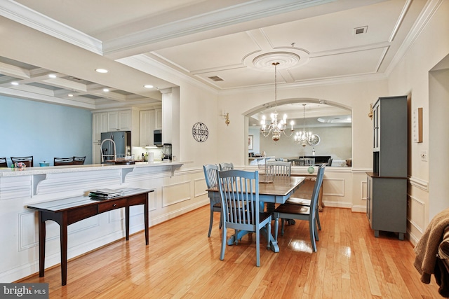 dining space featuring light wood finished floors, coffered ceiling, a decorative wall, and an inviting chandelier