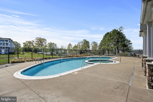 pool featuring a hot tub, fence, and a patio area