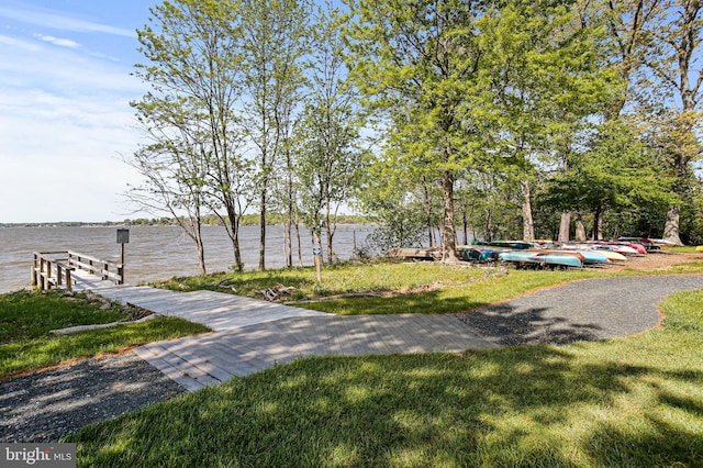 view of community with a water view and a lawn