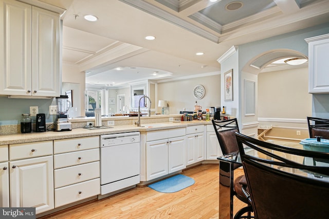 kitchen featuring a sink, a peninsula, light wood-type flooring, crown molding, and white dishwasher