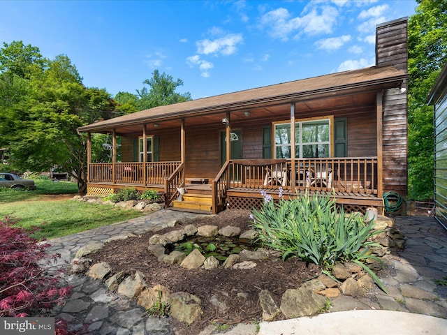 rustic home with covered porch and a chimney