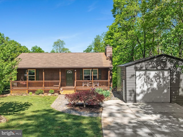 view of front of house with a porch, concrete driveway, an outdoor structure, a detached garage, and a front lawn
