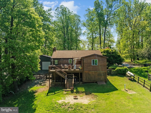rear view of property with a wooden deck, stairs, a fire pit, and a chimney