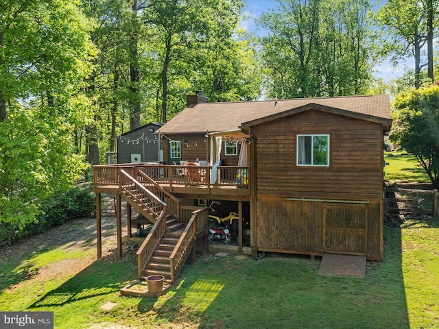 back of property featuring stairway, a wooden deck, a yard, a chimney, and roof with shingles
