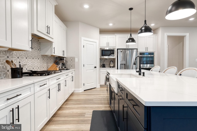 7679 Cross Creek Dr, Columbia, MD 21044 - kitchen featuring appliances with stainless steel finishes, a sink, white cabinets, light wood finished floors, and recessed lighting