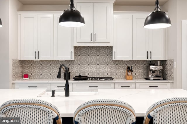 7679 Cross Creek Dr, Columbia, MD 21044 - kitchen with tasteful backsplash, white cabinetry, decorative light fixtures, and light stone counters