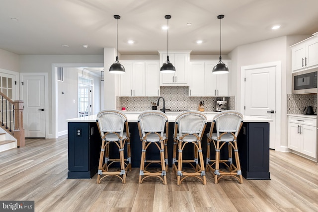 7679 Cross Creek Dr, Columbia, MD 21044 - kitchen with built in microwave, light wood-style flooring, light countertops, backsplash, and recessed lighting