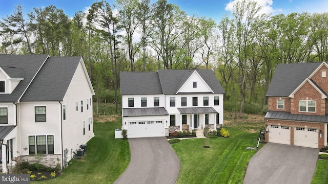 7679 Cross Creek Dr, Columbia, MD 21044 - view of front facade with a garage, asphalt driveway, a standing seam roof, stone siding, and a front yard