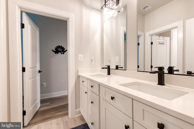 7679 Cross Creek Dr, Columbia, MD 21044 - bathroom featuring baseboards, double vanity, and wood finished floors