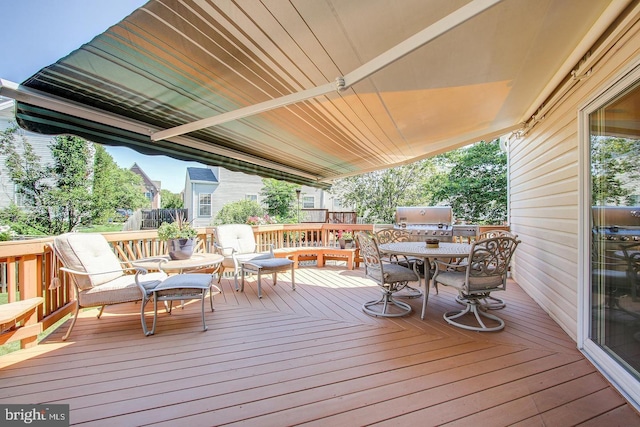 wooden terrace with outdoor dining space and grilling area