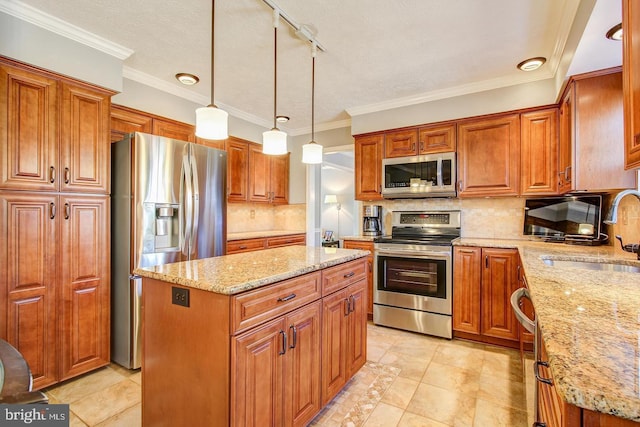 kitchen with stainless steel appliances, a sink, a kitchen island, light stone counters, and brown cabinets
