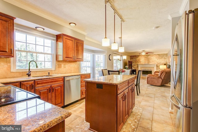 kitchen featuring appliances with stainless steel finishes, a textured ceiling, ceiling fan, a sink, and decorative backsplash