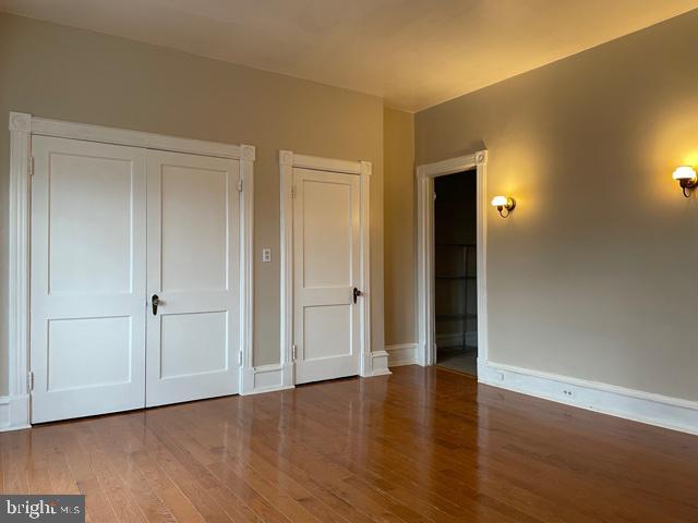 unfurnished bedroom with baseboards and wood finished floors