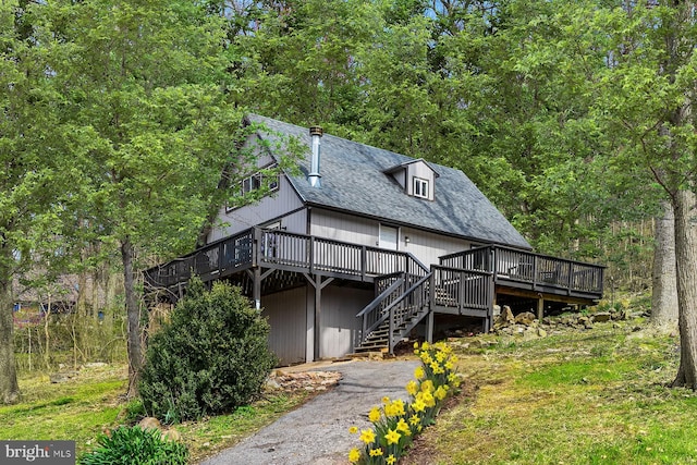 1125 Nancy Jack Rd, Gerrardstown, WV 25420 - view of front of property with a wooden deck, stairway, a shingled roof, and a wooded view