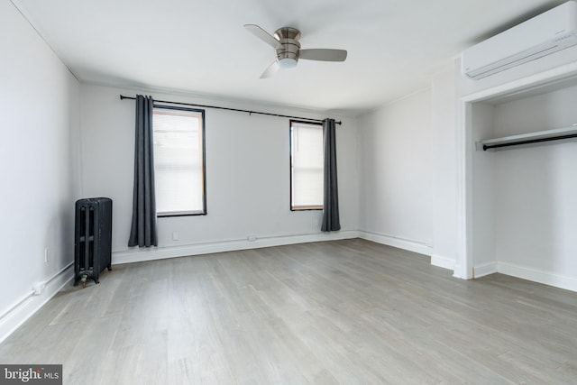 1545 S 19th St, Philadelphia, PA 19146 - unfurnished bedroom featuring radiator, baseboards, a wall unit AC, and wood finished floors