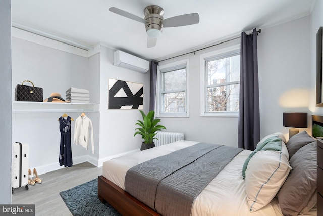 1545 S 19th St, Philadelphia, PA 19146 - bedroom with a ceiling fan, a wall mounted air conditioner, baseboards, radiator heating unit, and wood finished floors