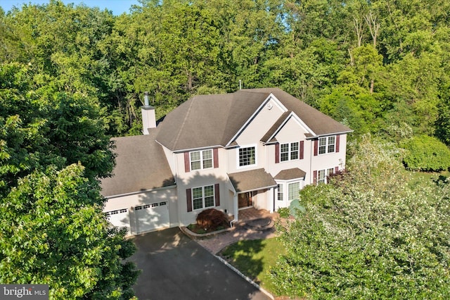 21 Jimarie Ct, Hamilton, NJ 08620 - view of front facade with asphalt driveway, an attached garage, a chimney, and a view of trees