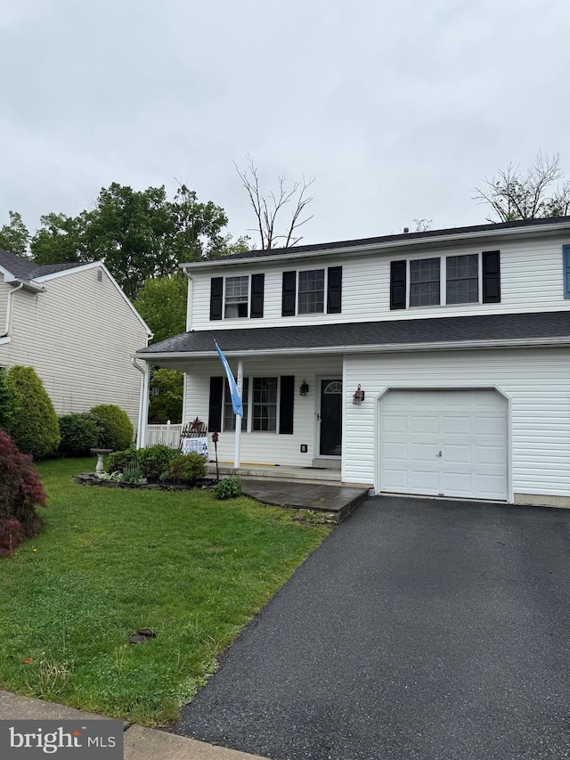traditional home with an attached garage, a porch, driveway, and a front yard