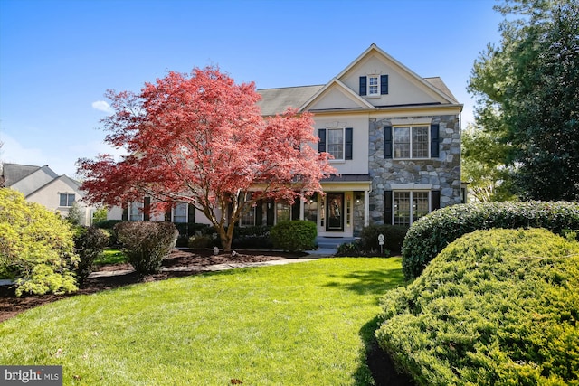 view of front of home featuring stone siding and a front lawn