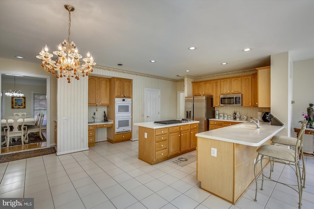 kitchen featuring appliances with stainless steel finishes, a chandelier, light countertops, a sink, and a kitchen island