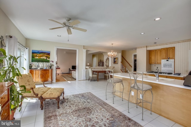 living room featuring a chandelier, ceiling fan, light tile patterned flooring, stairway, and recessed lighting