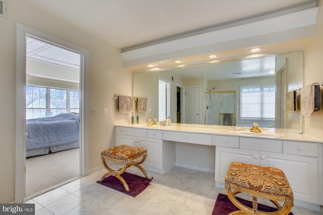 ensuite bathroom with a stall shower, recessed lighting, vanity, and marble look tiles