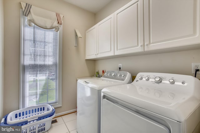 washroom with washing machine and clothes dryer, cabinet space, and light tile patterned floors