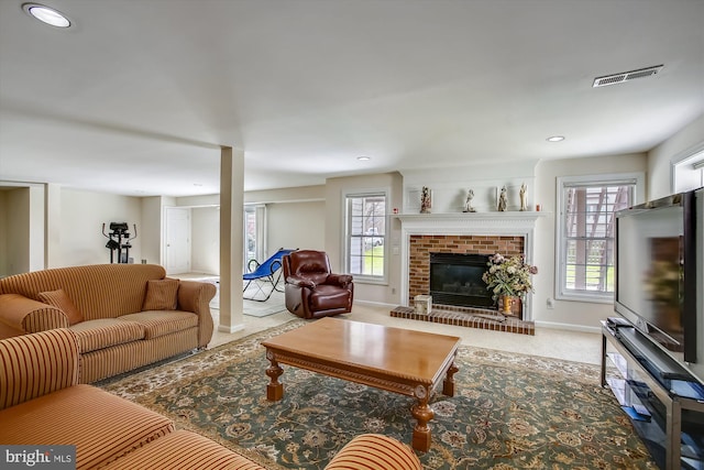 living area featuring healthy amount of natural light, a brick fireplace, baseboards, recessed lighting, and carpet flooring